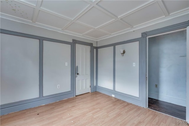 unfurnished bedroom with a barn door, hardwood / wood-style flooring, and coffered ceiling