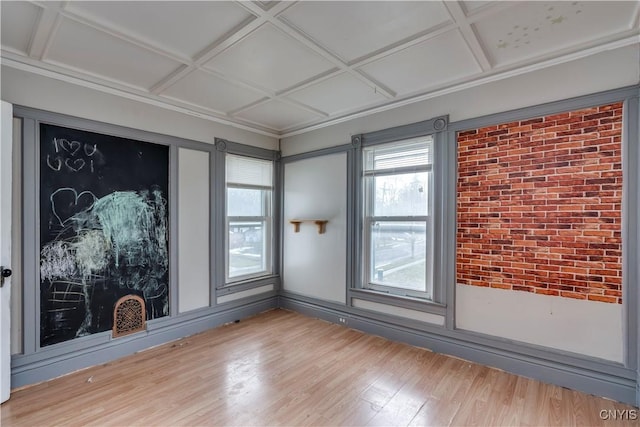 spare room featuring wood-type flooring, plenty of natural light, and coffered ceiling