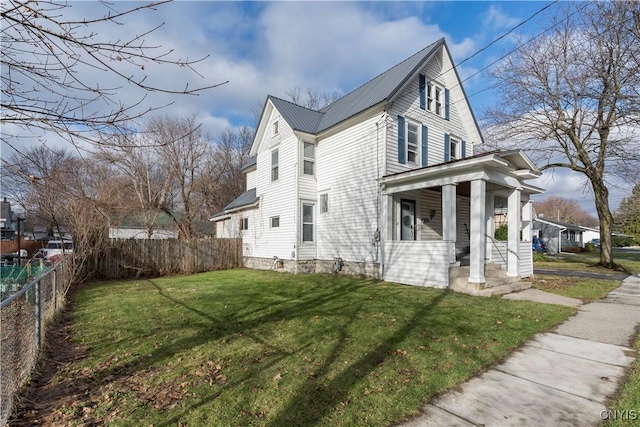 view of side of home featuring a lawn and covered porch