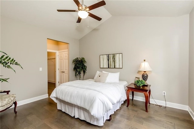 bedroom featuring a walk in closet, dark hardwood / wood-style floors, ceiling fan, and lofted ceiling