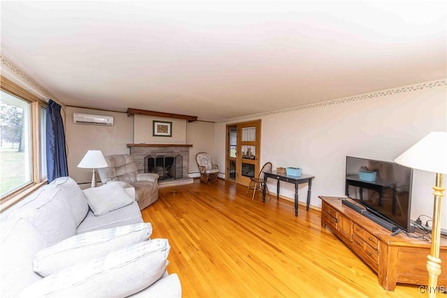 living room with a brick fireplace, a wall unit AC, and light hardwood / wood-style flooring