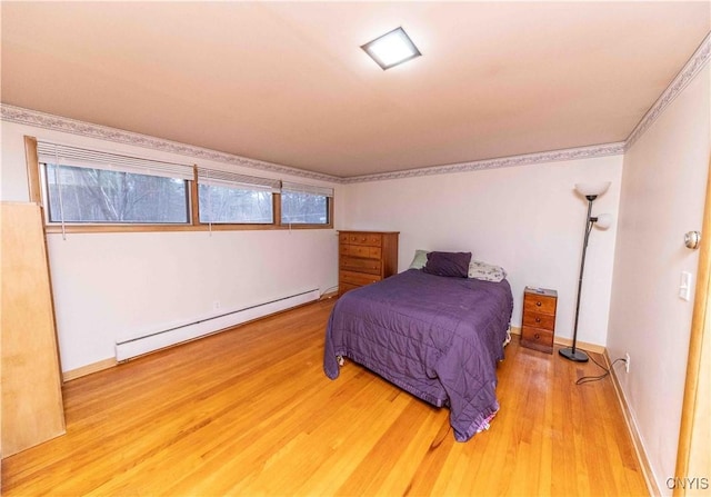 bedroom with hardwood / wood-style flooring and a baseboard radiator