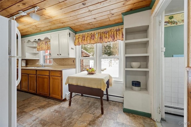 kitchen featuring wooden ceiling, white refrigerator, sink, decorative backsplash, and baseboard heating