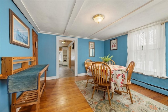 dining space with hardwood / wood-style floors and baseboard heating