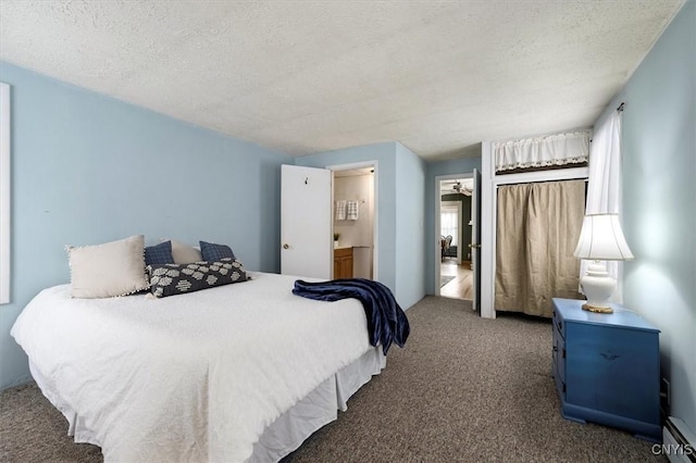 carpeted bedroom featuring baseboard heating and a textured ceiling