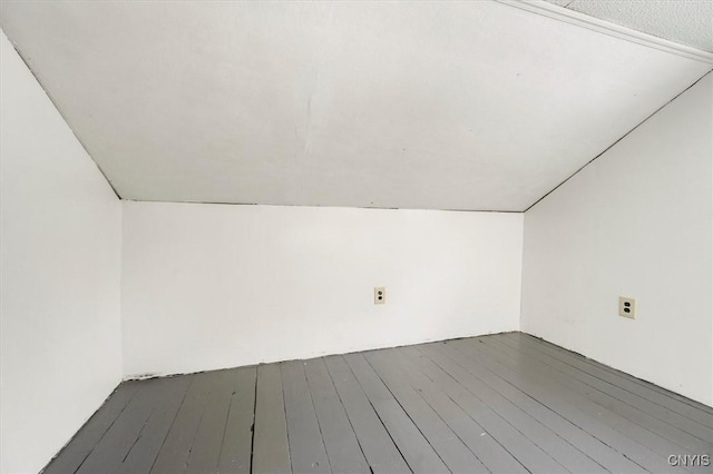 interior space featuring a textured ceiling, dark hardwood / wood-style floors, and vaulted ceiling