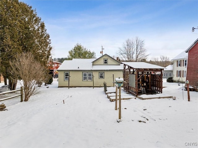 view of snow covered back of property