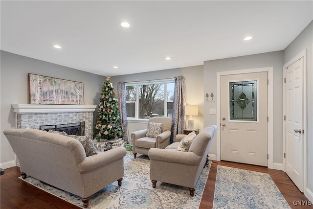 living room with hardwood / wood-style flooring and a brick fireplace