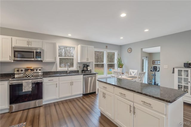 kitchen featuring dark stone counters, sink, dark hardwood / wood-style flooring, white cabinetry, and stainless steel appliances