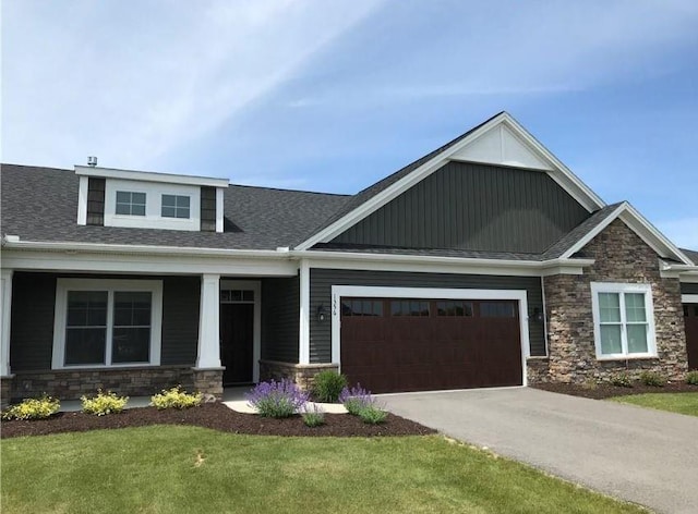 craftsman house featuring a garage and a front lawn