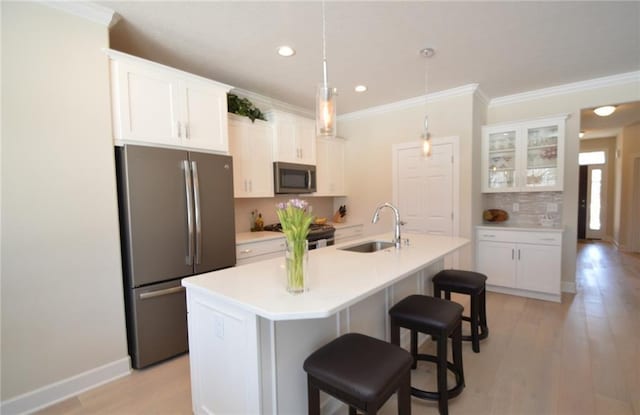 kitchen with white cabinetry, sink, stainless steel appliances, a breakfast bar area, and a kitchen island with sink