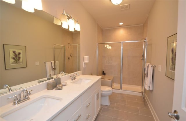 bathroom with tile patterned floors, vanity, toilet, and a shower with door