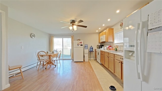 kitchen with ceiling fan, sink, a baseboard heating unit, white appliances, and light wood-type flooring