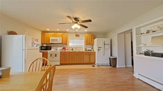 kitchen with white appliances, a baseboard heating unit, sink, ceiling fan, and light wood-type flooring