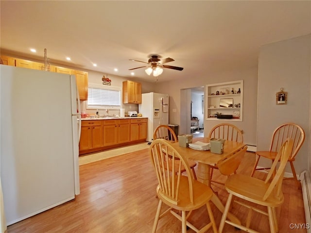 dining space featuring a baseboard radiator, ceiling fan, light hardwood / wood-style floors, and sink