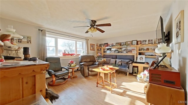 sitting room with light hardwood / wood-style floors and ceiling fan