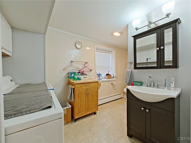 bathroom with vanity, washer / clothes dryer, toilet, and a baseboard heating unit