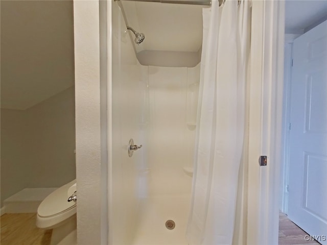 bathroom featuring hardwood / wood-style flooring, a shower with curtain, and toilet