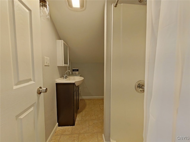 bathroom featuring curtained shower, vanity, and lofted ceiling