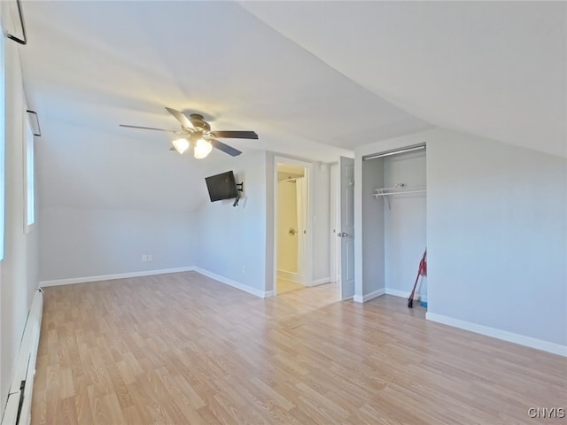 additional living space featuring light wood-type flooring, vaulted ceiling, baseboard heating, and ceiling fan