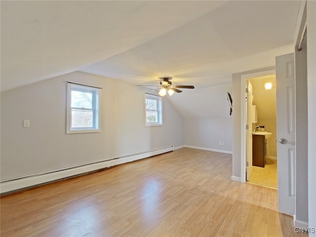 bonus room with ceiling fan, a baseboard radiator, vaulted ceiling, and light wood-type flooring