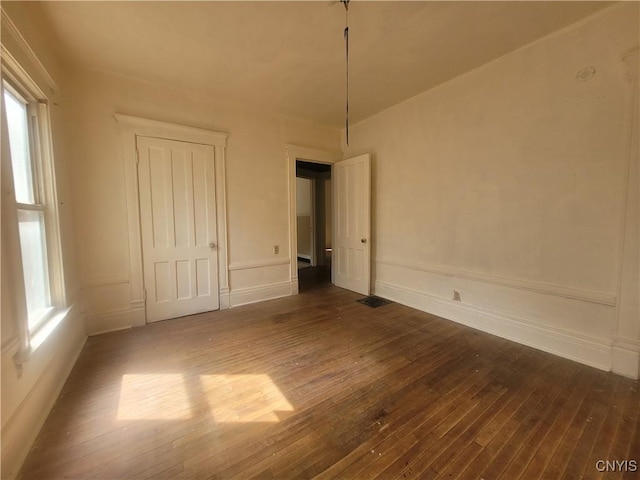 unfurnished bedroom with dark hardwood / wood-style flooring and a closet