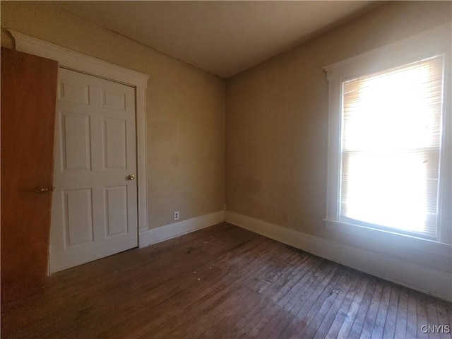 empty room featuring dark hardwood / wood-style flooring and a wealth of natural light