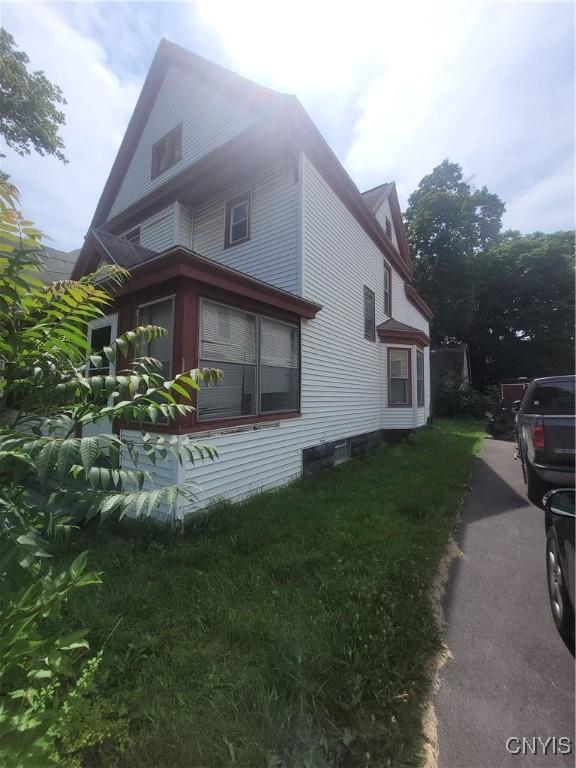 view of side of property with a lawn