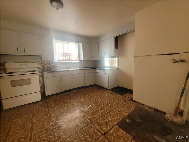 kitchen with white range with electric stovetop, sink, and white cabinets