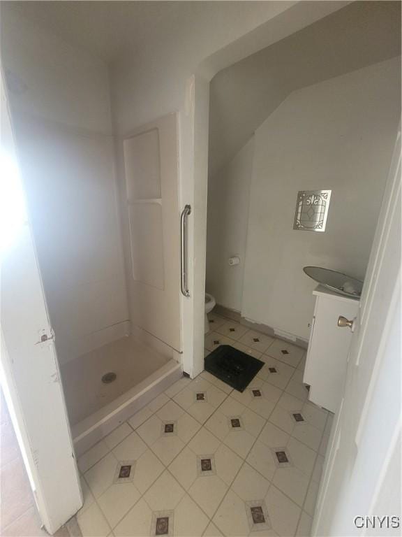 bathroom with a shower, vanity, tile patterned floors, and toilet