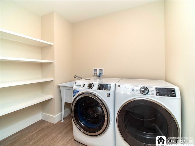 laundry area with hardwood / wood-style floors and washing machine and clothes dryer