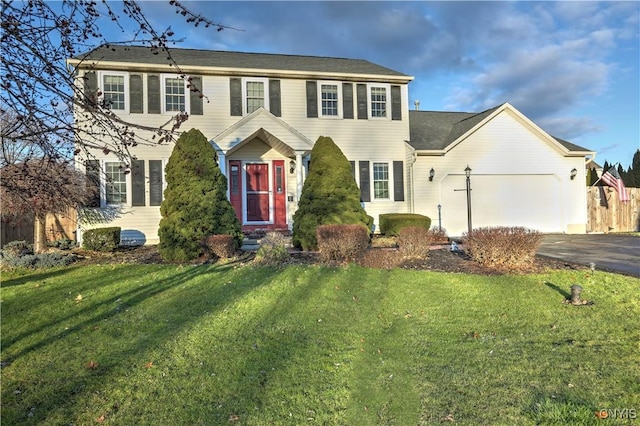 colonial-style house with a garage and a front lawn