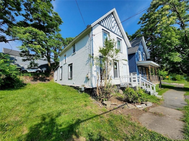 view of property exterior featuring covered porch and a yard