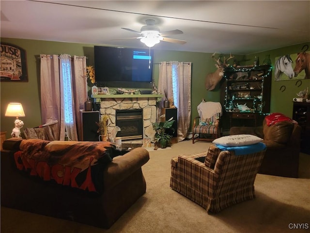 carpeted living room with ceiling fan and a fireplace