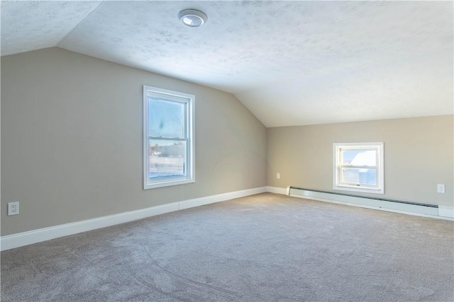 bonus room featuring carpet flooring, a textured ceiling, vaulted ceiling, and a baseboard heating unit