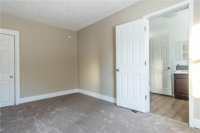 unfurnished bedroom featuring a textured ceiling and light carpet