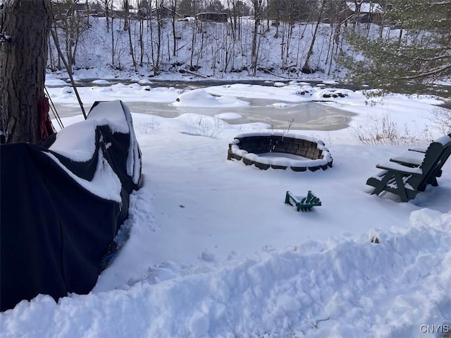 yard layered in snow featuring an outdoor fire pit