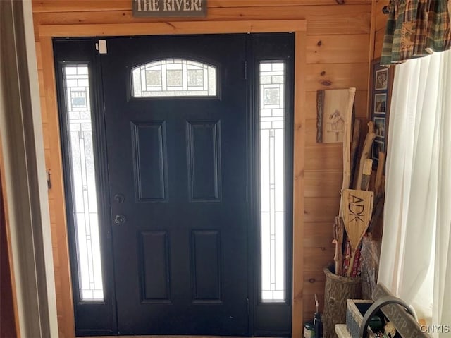 foyer entrance with a healthy amount of sunlight and wooden walls