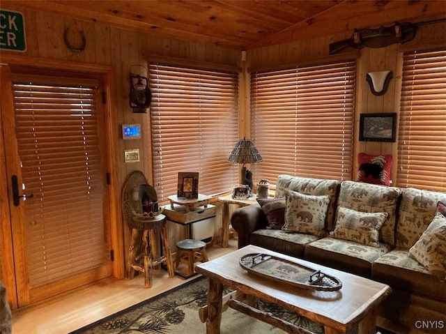 living room with vaulted ceiling, wooden walls, and wood ceiling