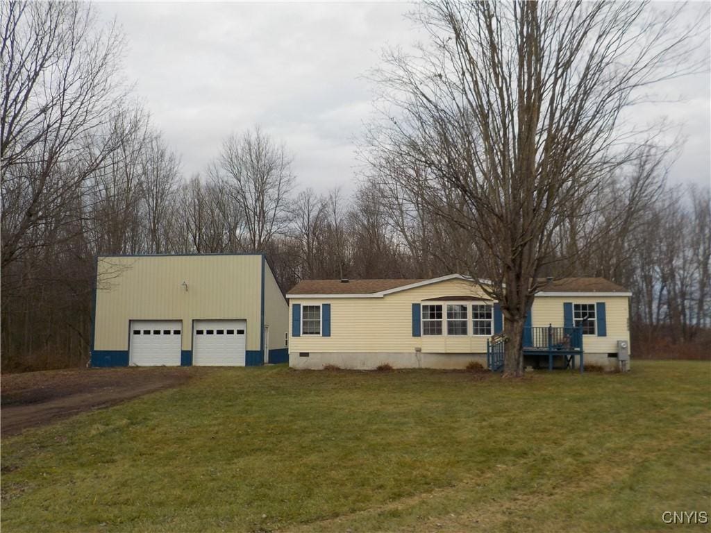 view of front of house featuring an outbuilding and a front lawn