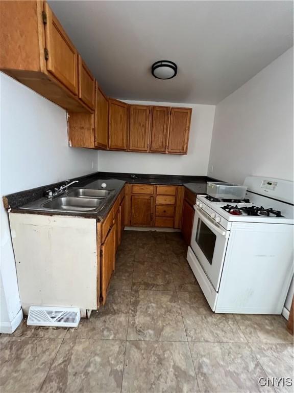 kitchen featuring white gas stove and sink