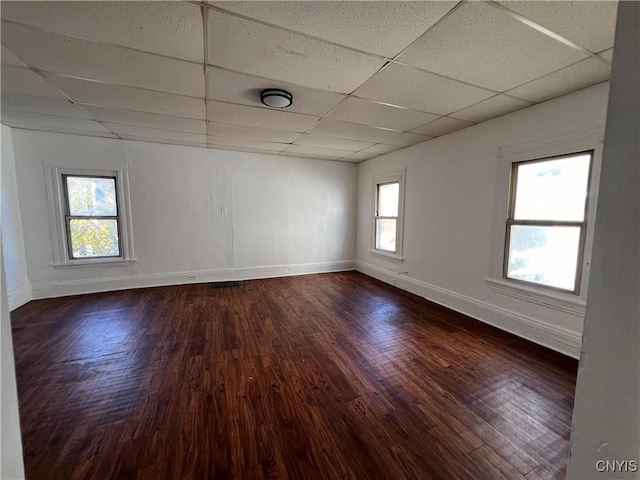 unfurnished room with a paneled ceiling and dark wood-type flooring