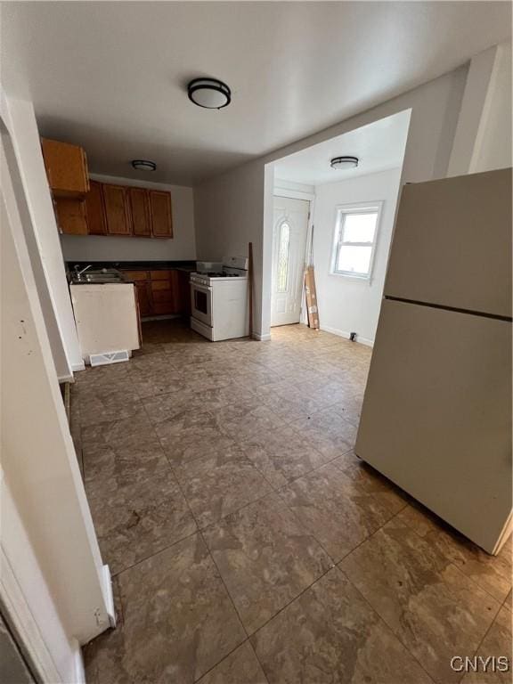 kitchen with white gas stove and fridge