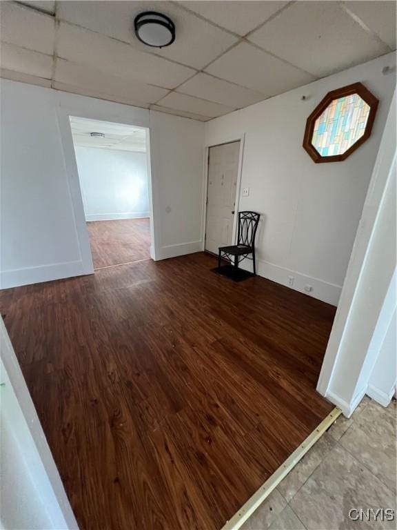 empty room with hardwood / wood-style floors and a drop ceiling