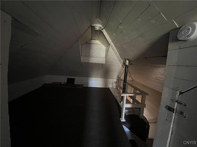 additional living space with wood walls and lofted ceiling