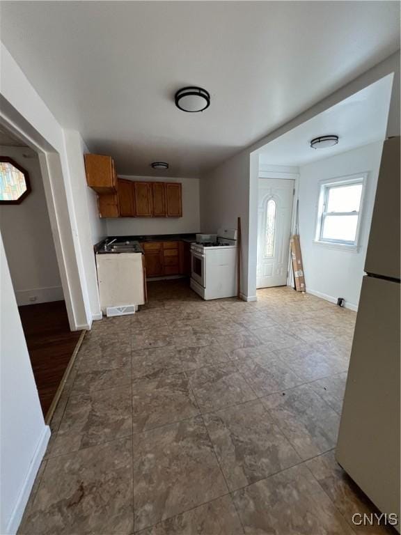 kitchen featuring white gas range and stainless steel fridge