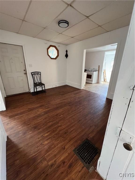 interior space featuring dark hardwood / wood-style flooring and a drop ceiling