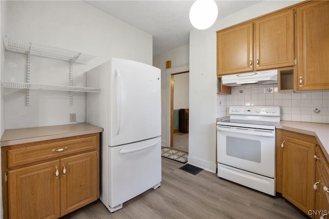 kitchen featuring decorative backsplash, white appliances, and light hardwood / wood-style flooring