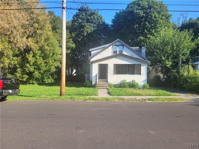 bungalow-style house featuring a front lawn