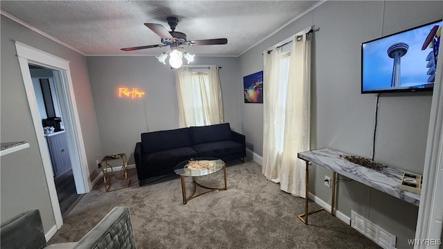 carpeted living room with a textured ceiling, ceiling fan, and crown molding